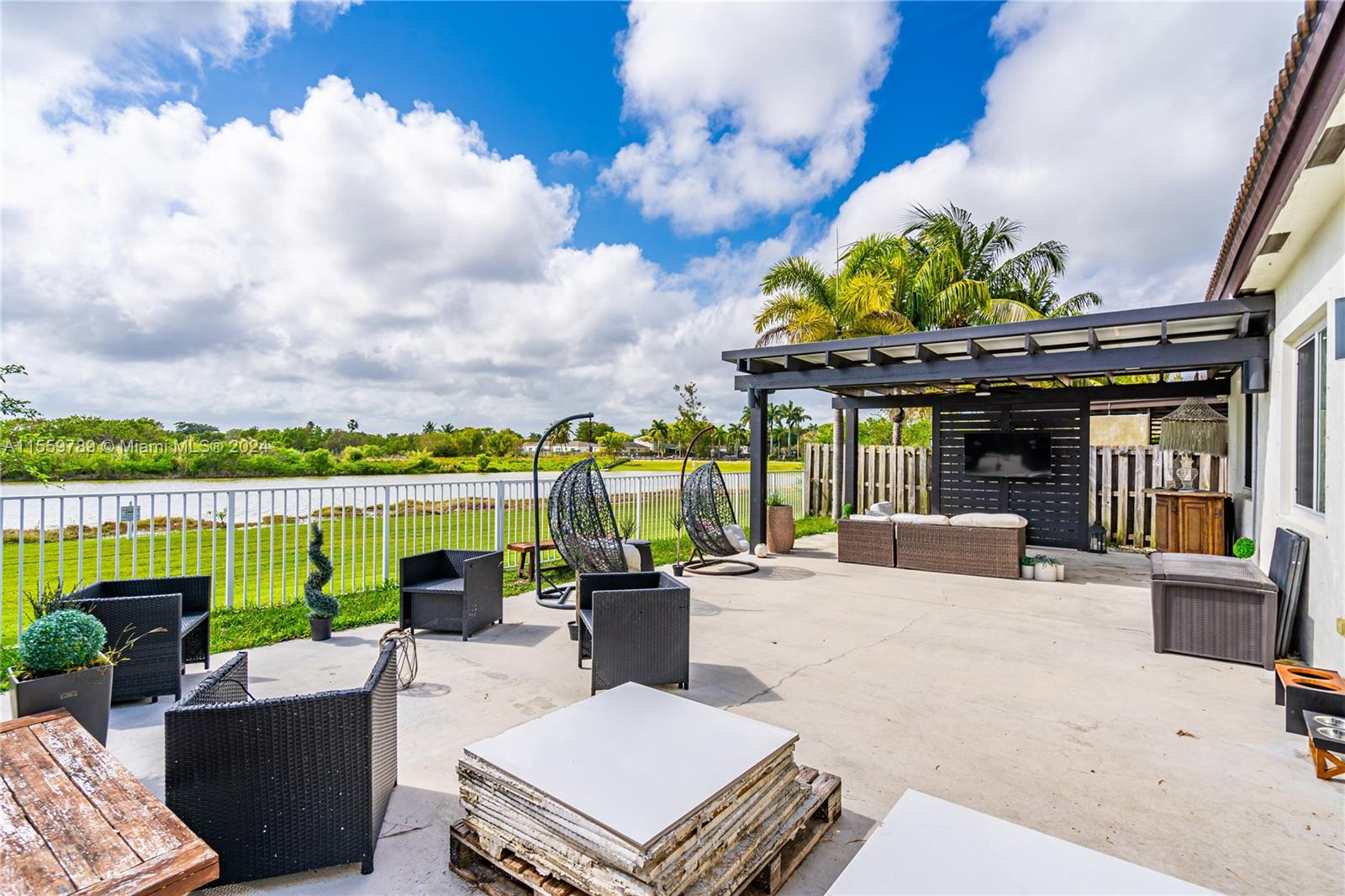 22438 Southwest 94th Path Cutler Bay, FL 33190 - Photo 25 of 38 a view of a patio with couches potted plants and lake view