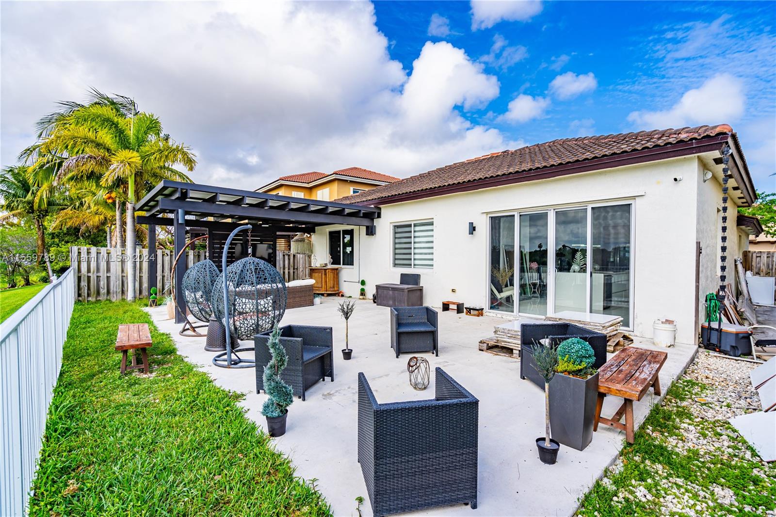 22438 Southwest 94th Path Cutler Bay, FL 33190 - Photo 26 of 38 a view of a patio with table and chairs potted plants with wooden fence