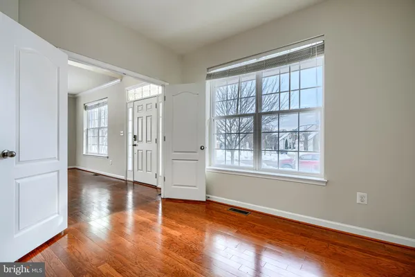 a view of empty room with a fireplace and wooden floor