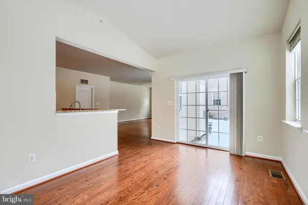 a view of a livingroom with wooden floor a fireplace and a ceiling fan