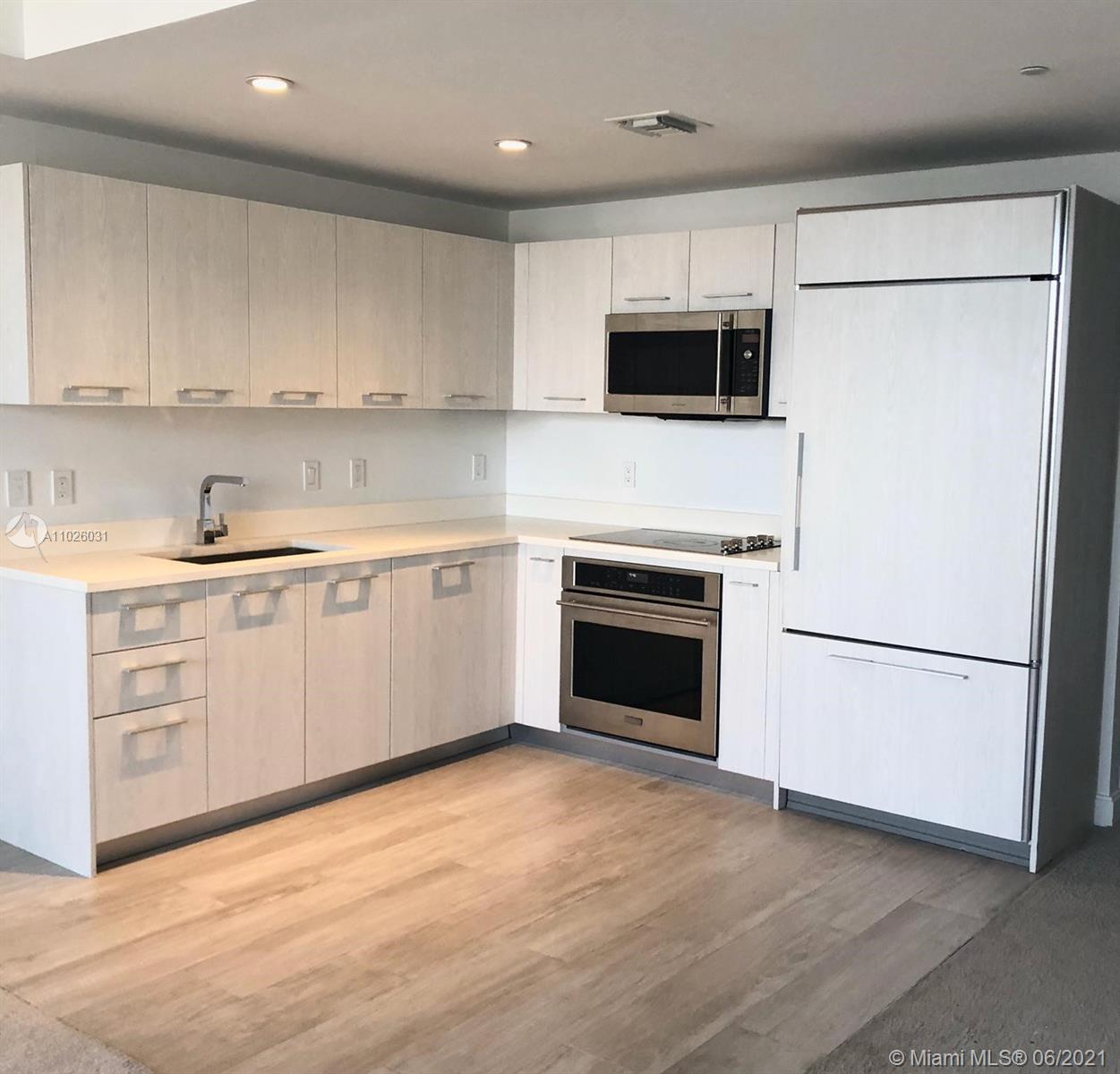 45 Southwest 9th Street, Unit 3102 Miami, FL 33130 - Photo 2 of 19 a kitchen with cabinets stainless steel appliances and sink
