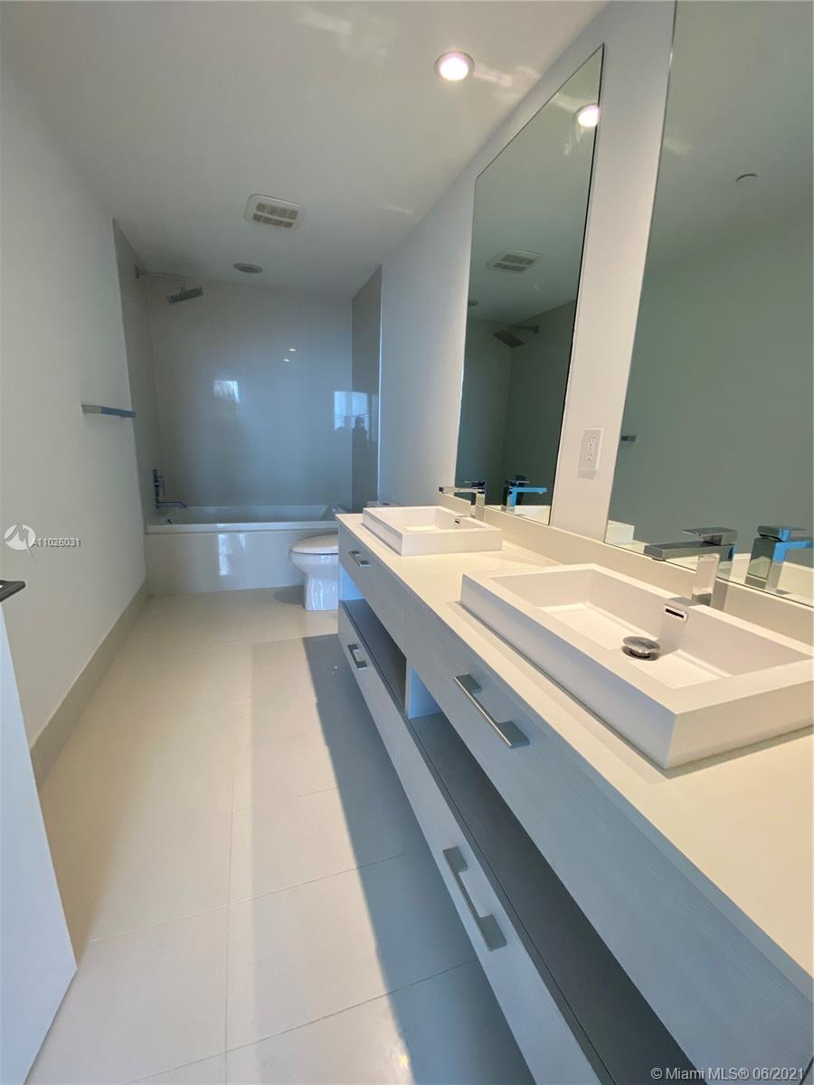 45 Southwest 9th Street, Unit 3102 Miami, FL 33130 - Photo 6 of 19 a bathroom with a sink a large mirror and a bathtub