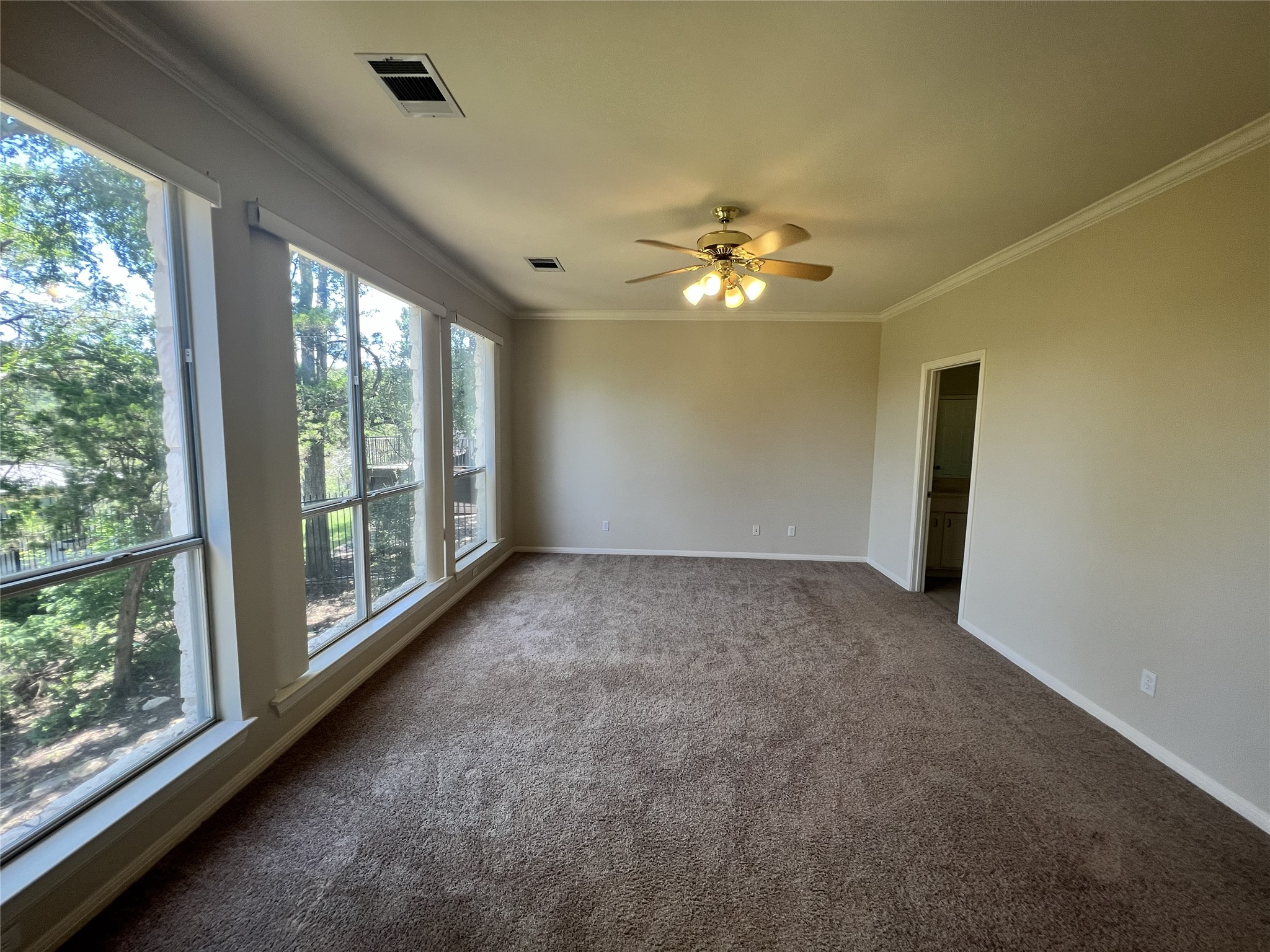 9405 Ashton Ridge Austin, TX 78750 - Photo 17 of 22 Ample natural light illuminates this spacious living area with treetop views and a warm carpet underfoot.