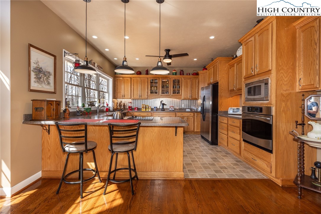 181 Abbey Road McGrady, NC 28649 - Photo 18 of 50 a kitchen with stainless steel appliances granite countertop a refrigerator a stove top oven a sink dishwasher and white cabinets with wooden floor