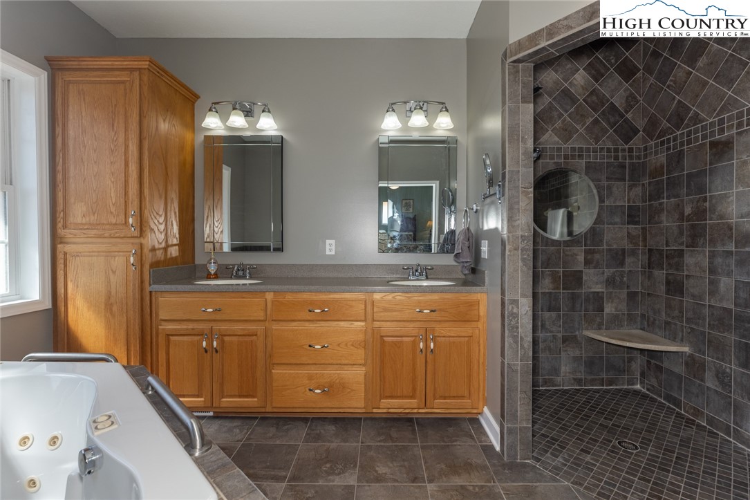 181 Abbey Road McGrady, NC 28649 - Photo 29 of 50 a bathroom with a granite countertop sink a mirror and shower