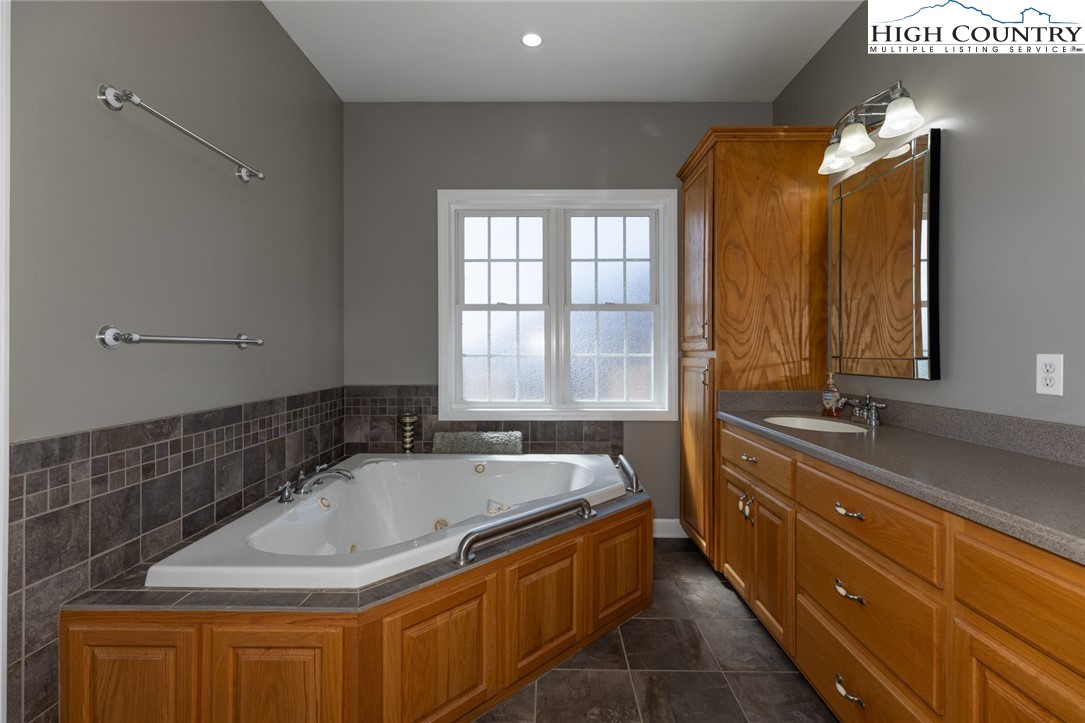 181 Abbey Road McGrady, NC 28649 - Photo 31 of 50 a bathroom with a tub sink and mirror