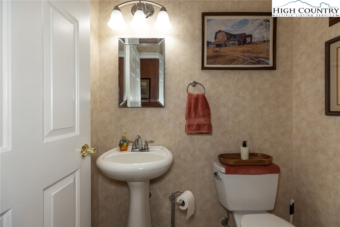 181 Abbey Road McGrady, NC 28649 - Photo 44 of 50 a bathroom with a toilet a sink and mirror