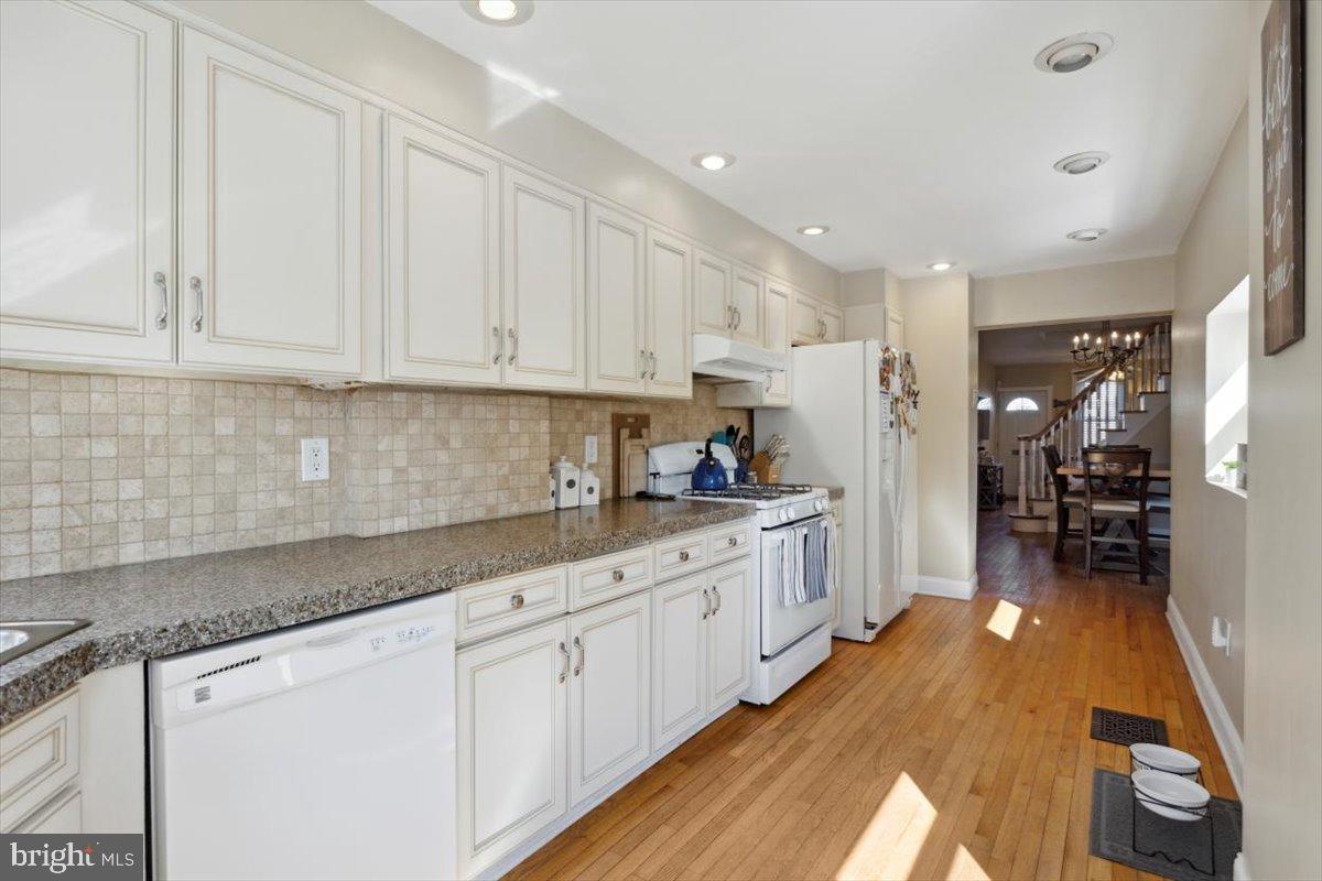 214 Ripka Street Philadelphia, PA 19127 - Photo 7 of 15 a kitchen with granite countertop white cabinets and white appliances