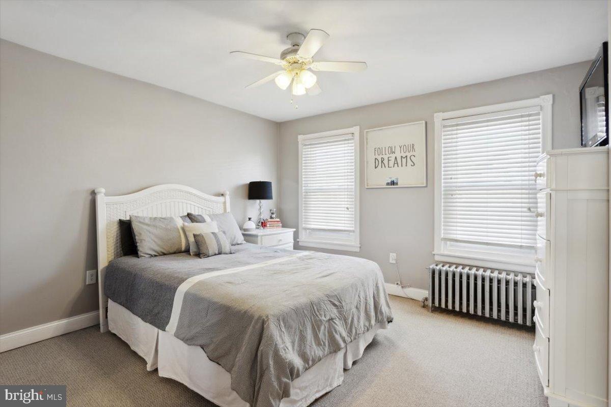 214 Ripka Street Philadelphia, PA 19127 - Photo 8 of 15 a bedroom with a bed a window and a chandelier