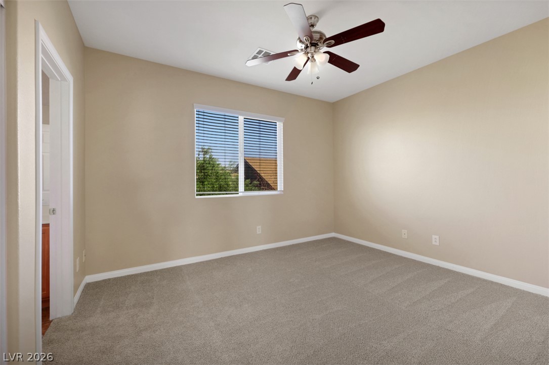 10328 Hawk Ravine Street Las Vegas, NV 89178 - Photo 35 of 55 A well-lit bedroom features plush carpeting and a modern ceiling fan for year-round comfort.