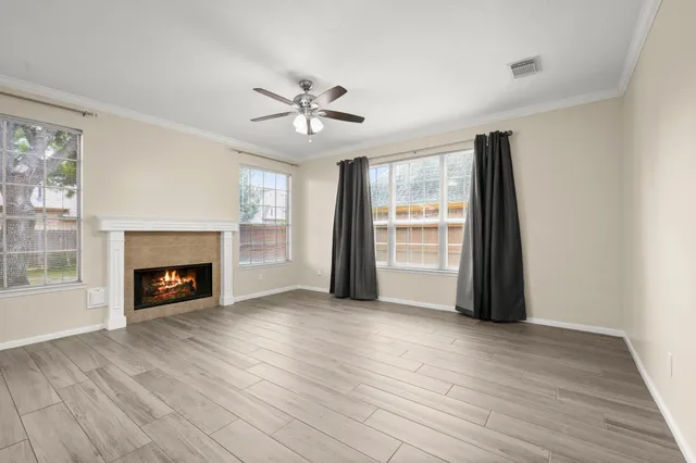 a view of empty room with wooden floor and fireplace