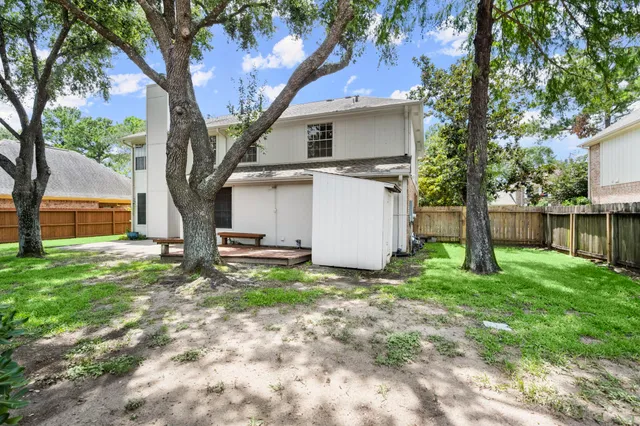 a view of a house with backyard and a tree