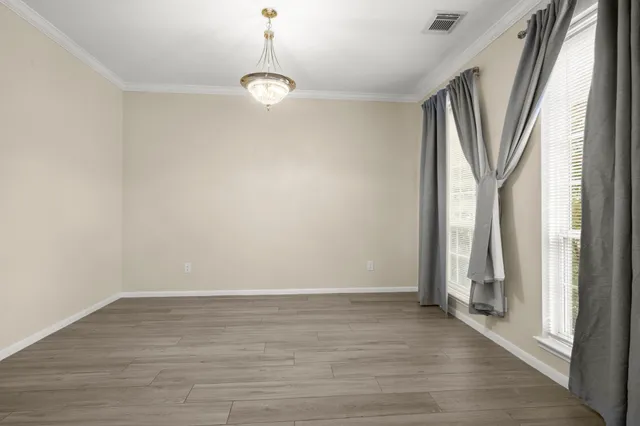 a bathroom with a granite countertop sink a toilet and a window