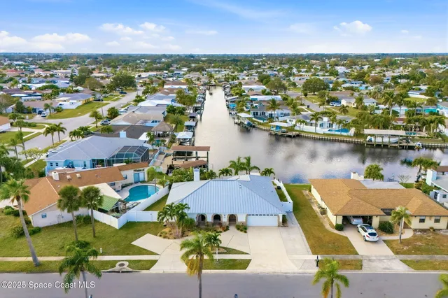 an aerial view of residential houses with outdoor space and lake view