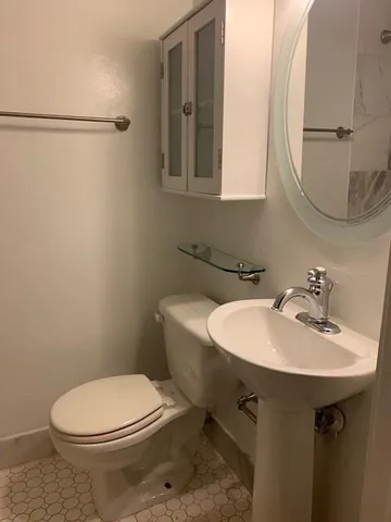 a bathroom with a sink a toilet and mirror