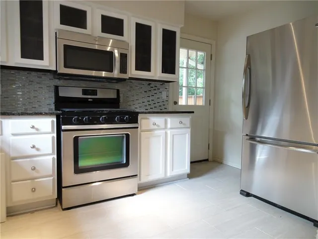 a kitchen with stainless steel appliances a stove microwave and refrigerator