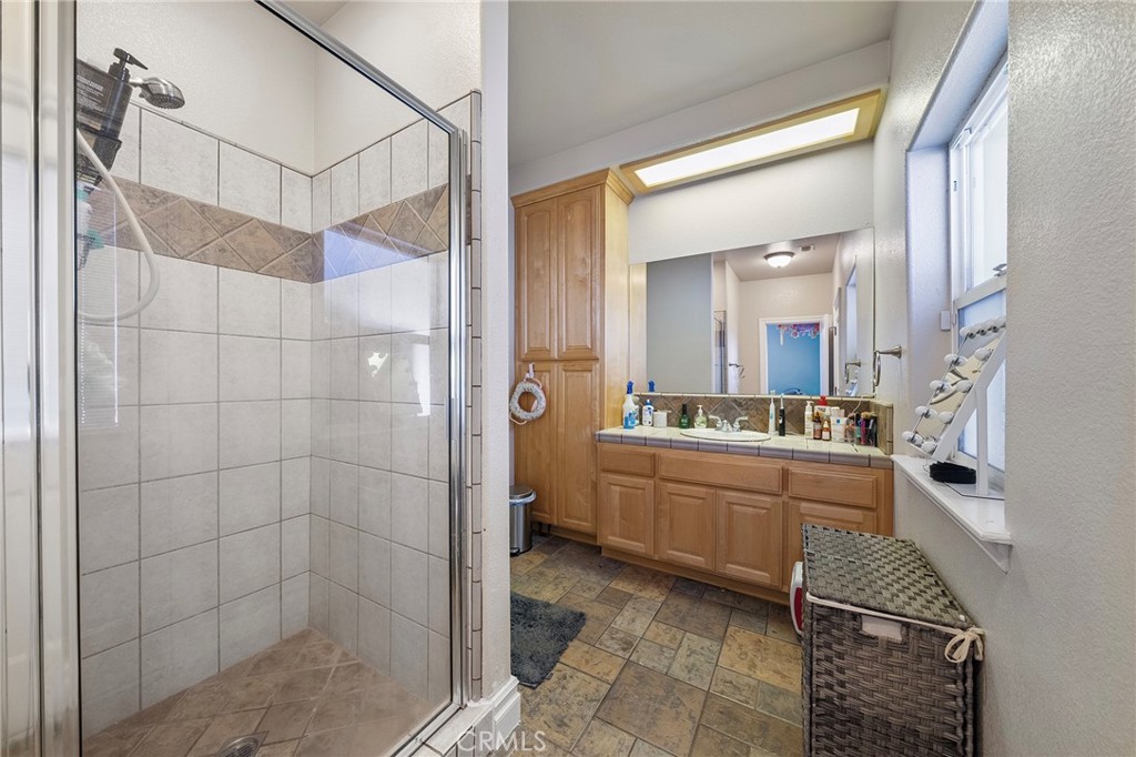 7172 Jargon Road Hesperia, CA 92344 - Photo 25 of 75 a large bathroom with a granite countertop sink a mirror and shower