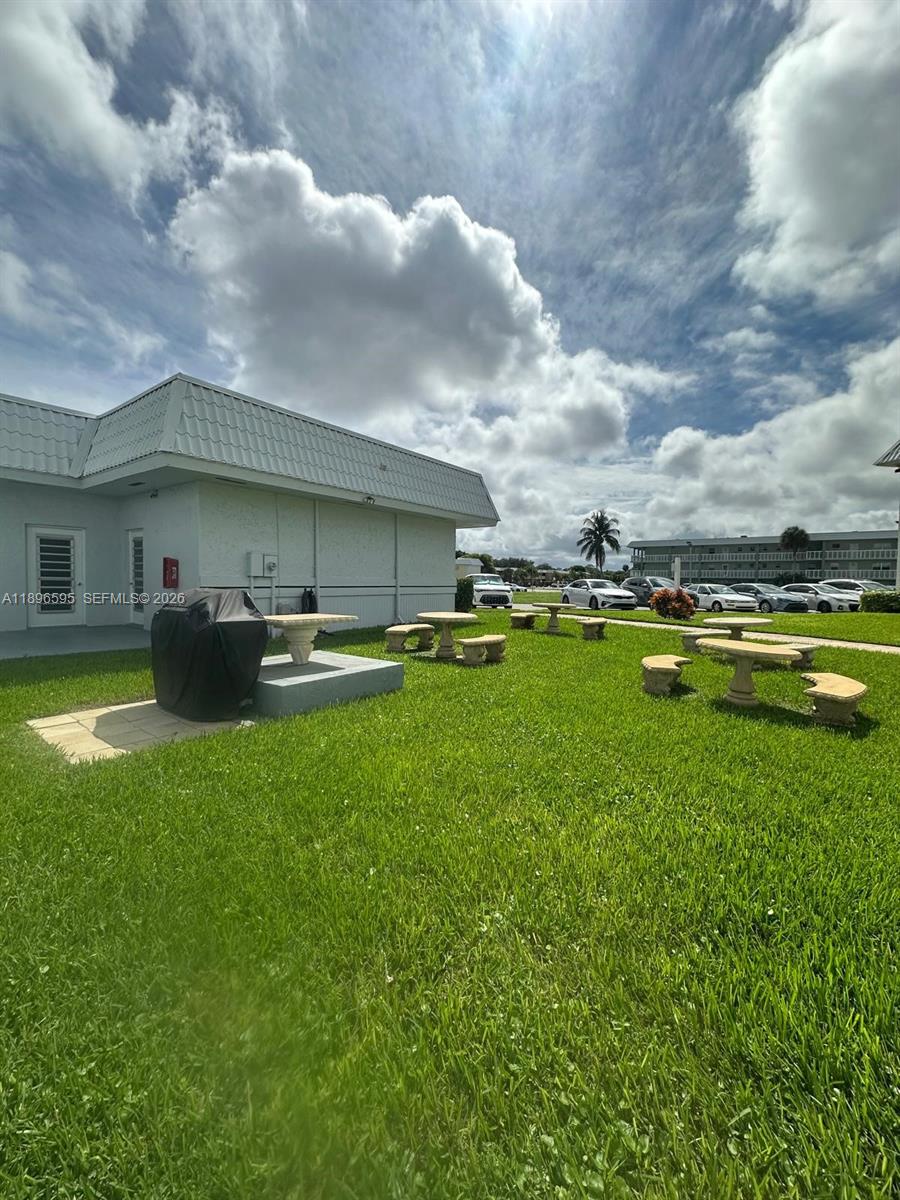 9848 Marina Boulevard, Unit 811 Boca Raton, FL 33428 - Photo 79 of 86 a view of a house with a swimming pool and a yard