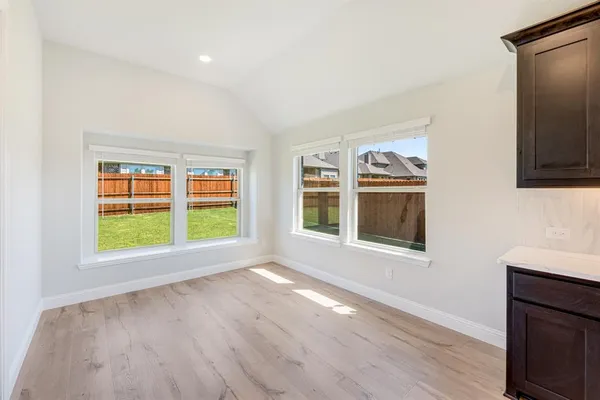 a large kitchen with stainless steel appliances kitchen island granite countertop a refrigerator and a wooden cabinets