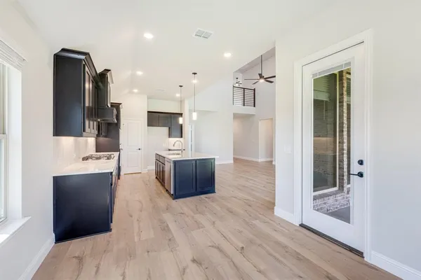 a kitchen with kitchen island a stove a sink and a refrigerator