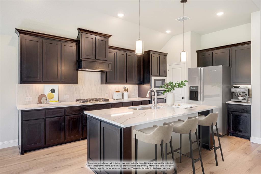 1025 Raptor Road Alvarado, TX 76009 - Photo 13 of 40 a kitchen with stainless steel appliances kitchen island granite countertop a sink refrigerator and cabinets
