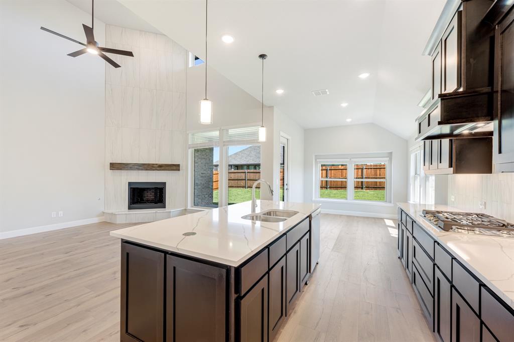 1025 Raptor Road Alvarado, TX 76009 - Photo 17 of 40 a kitchen with kitchen island a stove a sink and a refrigerator