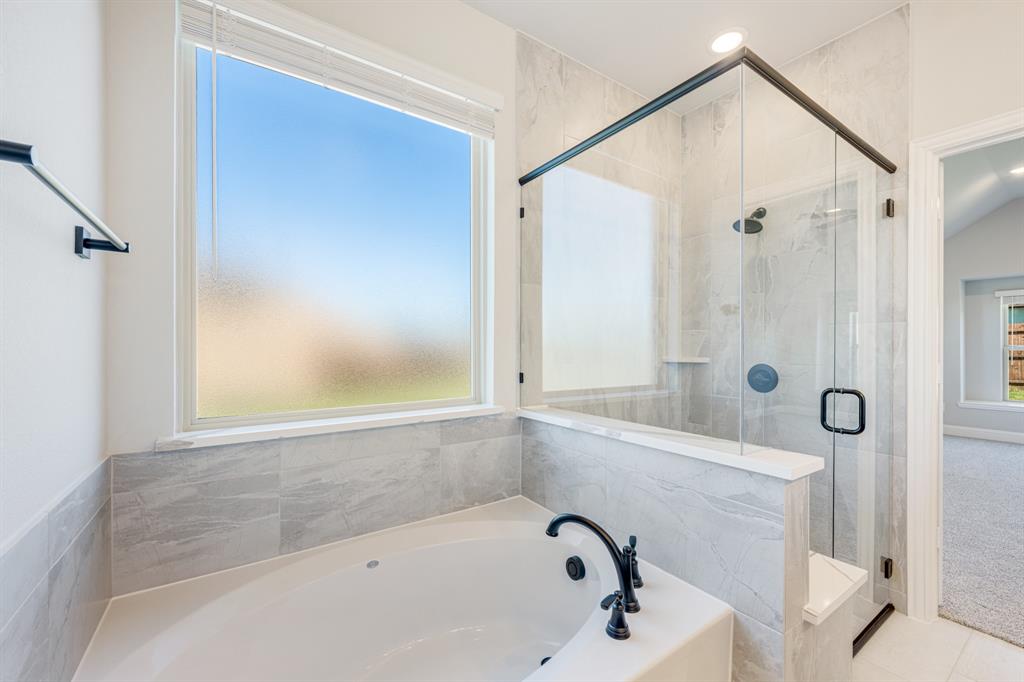 1025 Raptor Road Alvarado, TX 76009 - Photo 24 of 40 a bathroom with a tub and a shower