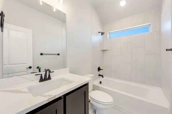 an empty room with wooden floor a ceiling fan and windows