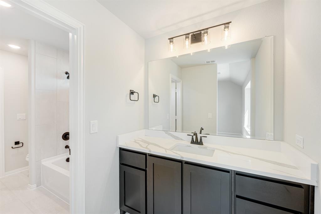 1025 Raptor Road Alvarado, TX 76009 - Photo 33 of 40 a bathroom with a sink vanity granite tub shower and a mirror
