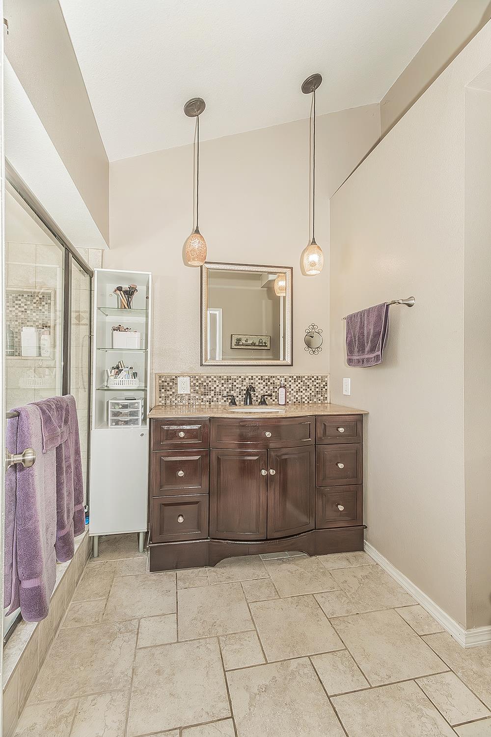 1908 East Niles Avenue Fresno, CA 93720 - Photo 16 of 30 a spacious bathroom with a granite countertop sink a mirror and a shower