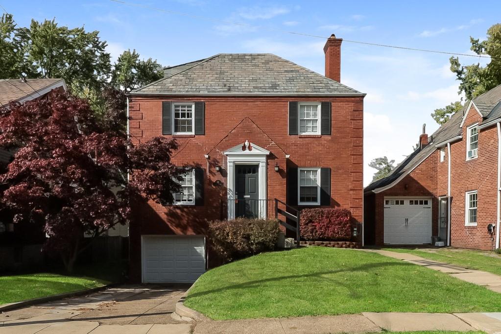 a front view of a house with a garden