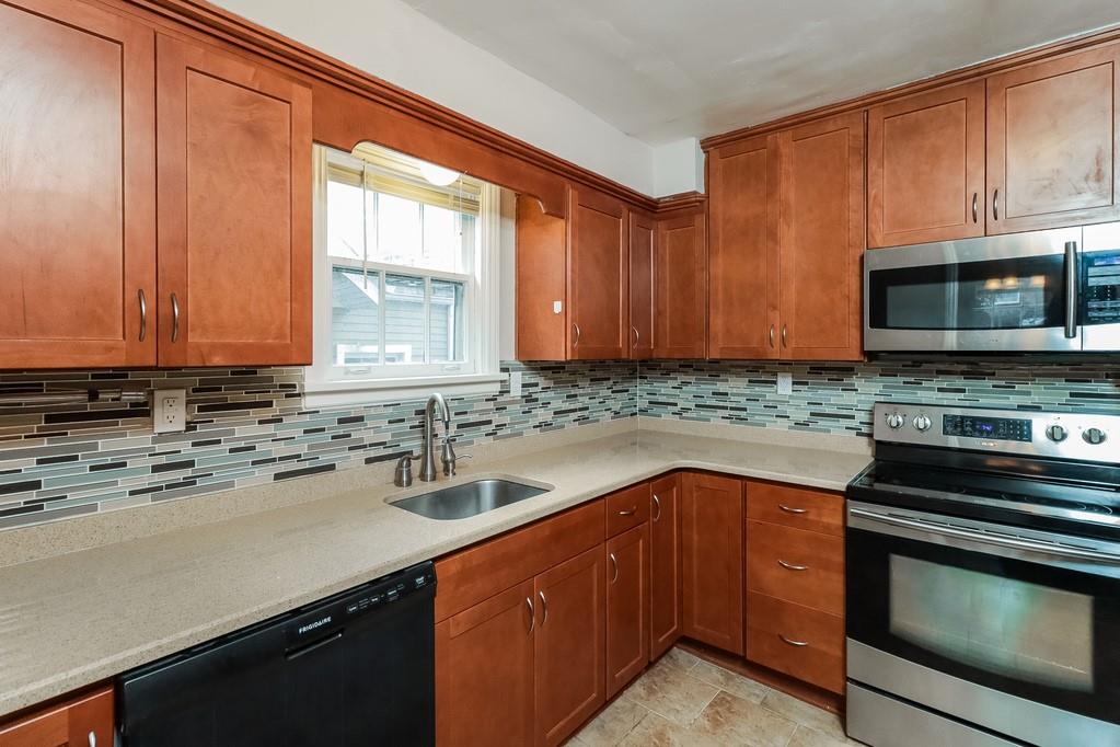 18 Alice Street Pittsburgh, PA 30342 - Photo 4 of 11 a kitchen with stainless steel appliances a stove sink microwave and cabinets