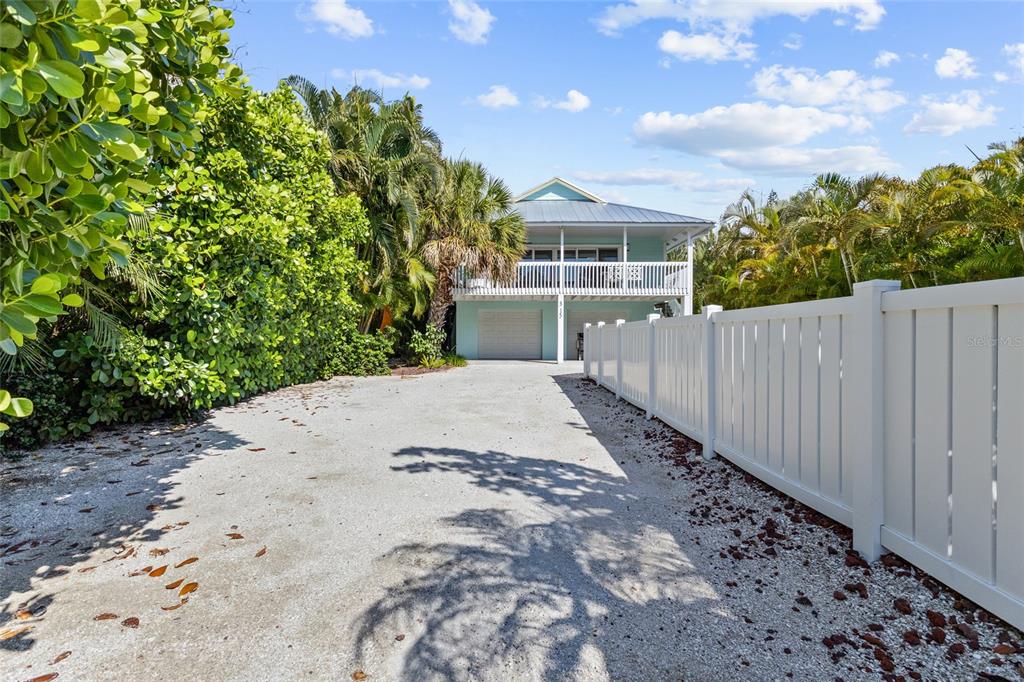315 Spring Avenue Anna Maria, FL 34216 - Photo 1 of 63 a view of a white house with a yard and wooden fence