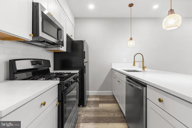 a kitchen with stainless steel appliances granite countertop a stove and a sink