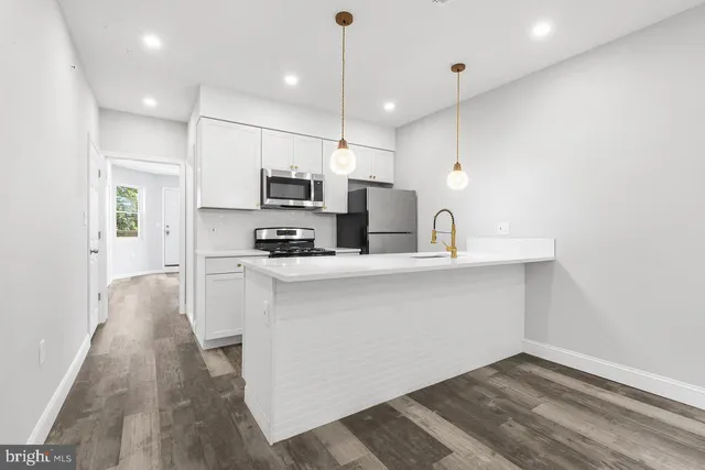a kitchen with kitchen island a sink stainless steel appliances and cabinets
