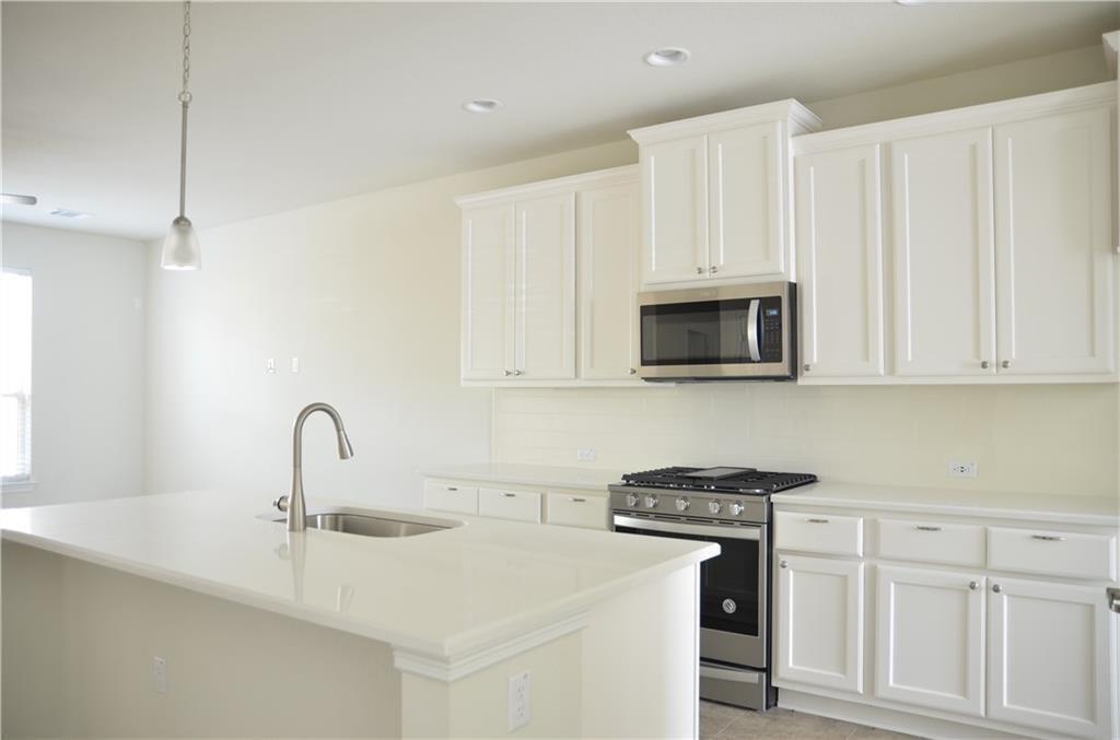 14403 McCoy Loop Austin, TX 78717 - Photo 3 of 29 White cabinetry and sleek appliances elevate this kitchen's practical appeal.