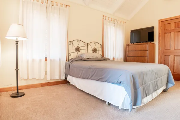 a view of a backyard with wooden fence and large trees