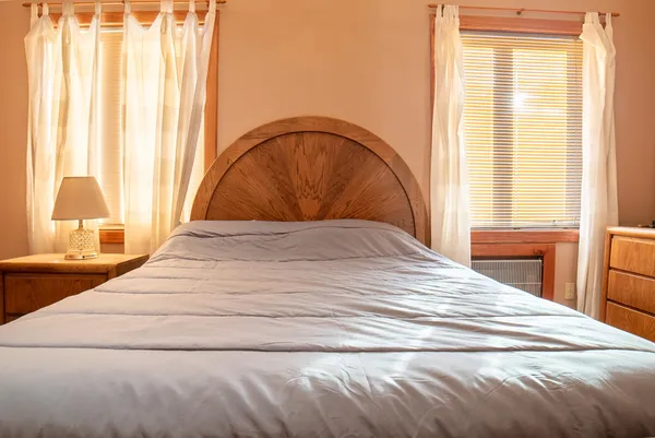 a bedroom with a bed and a large window