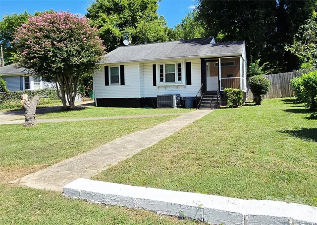 a front view of a house with a yard and trees