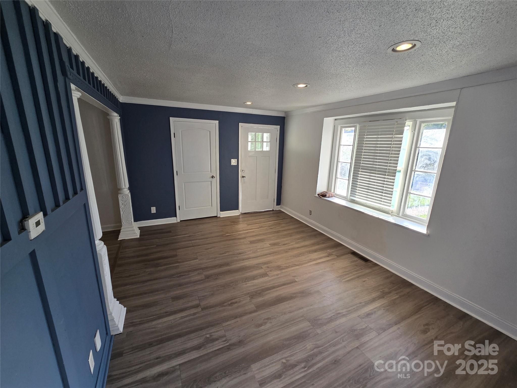 1900 Double Oaks Road Charlotte, NC 28206 - Photo 3 of 22 a view of an empty room with wooden floor and a window