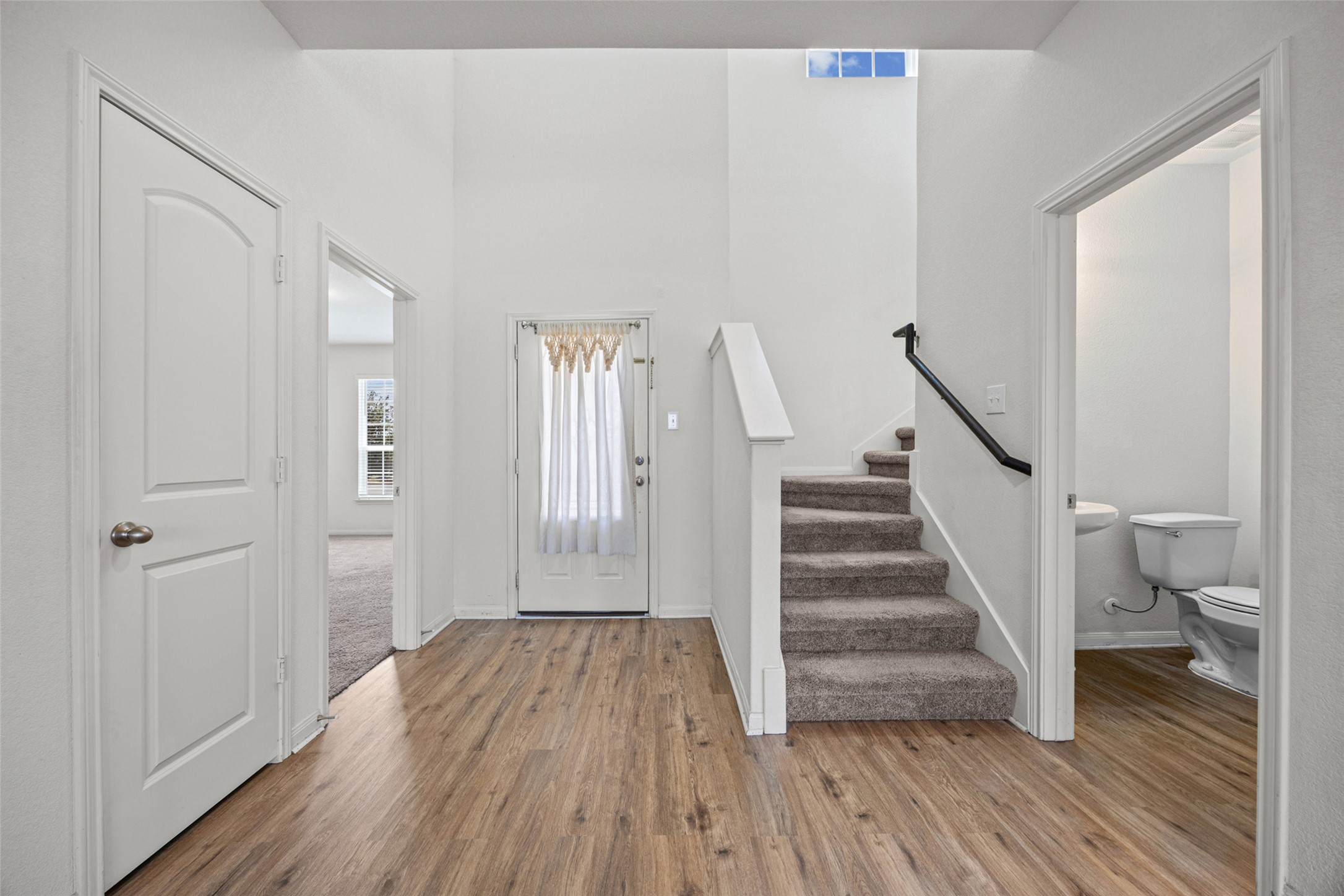 19812 Hubert R Humphrey Road Manor, TX 78653 - Photo 7 of 29 A welcoming entryway features high ceilings, light wood flooring, and a carpeted staircase leading to the upper level.