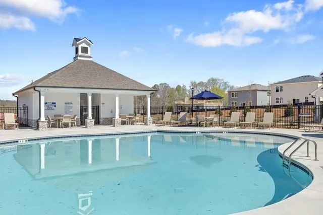 a view of a house with pool and chairs