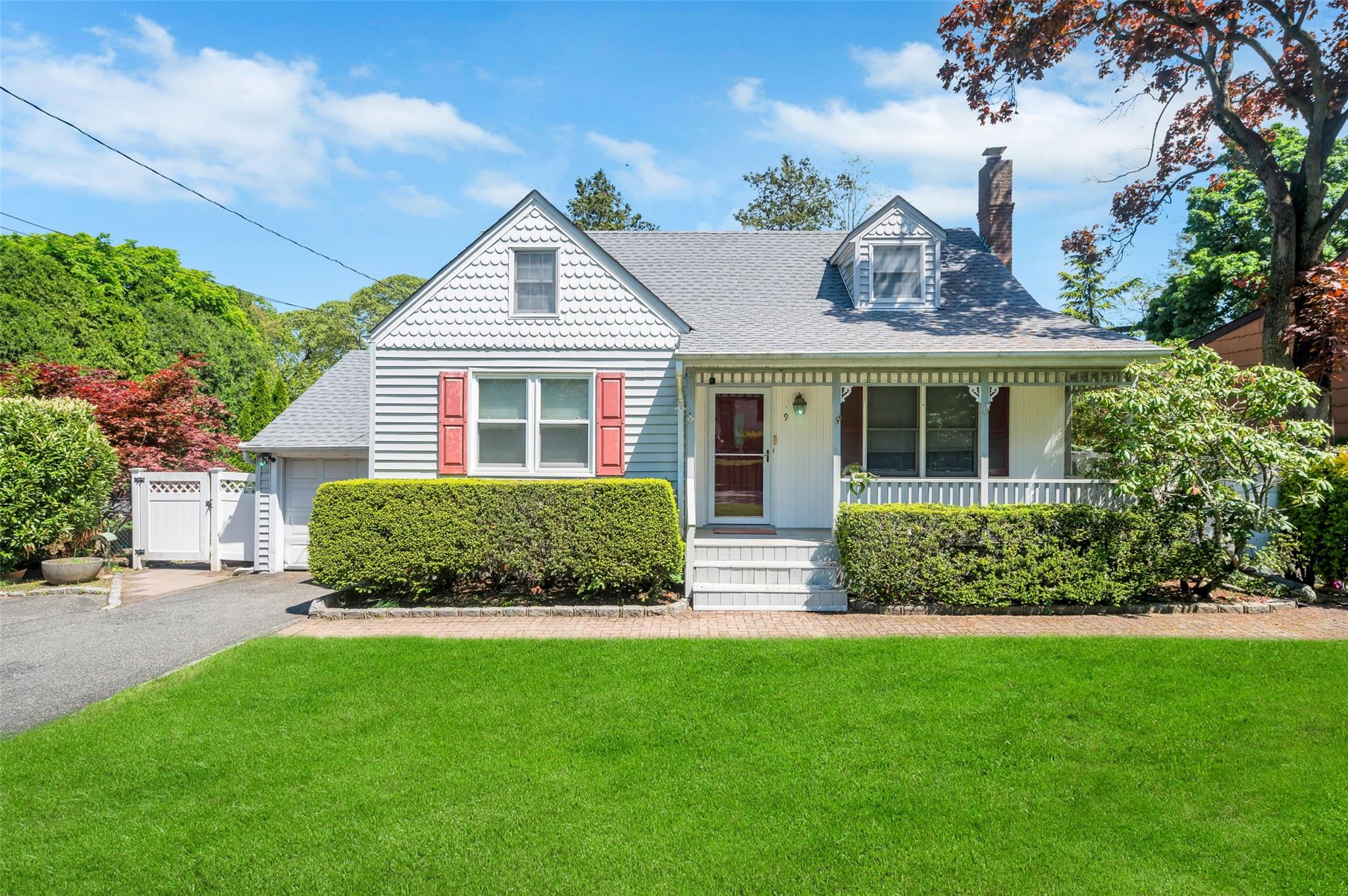 Victorian house with a chimney, a front yard, covered porch, and roof with shingles