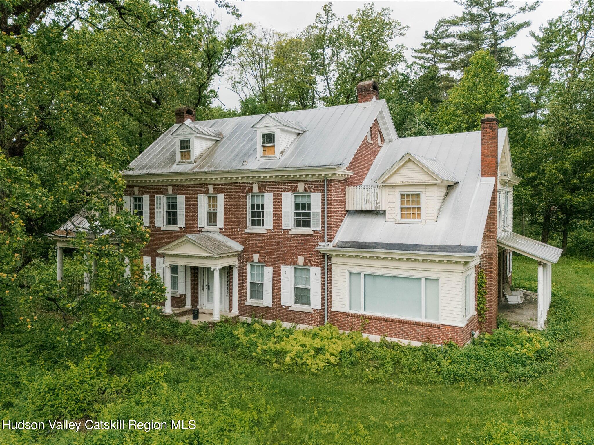 a front view of a house with a garden and plants