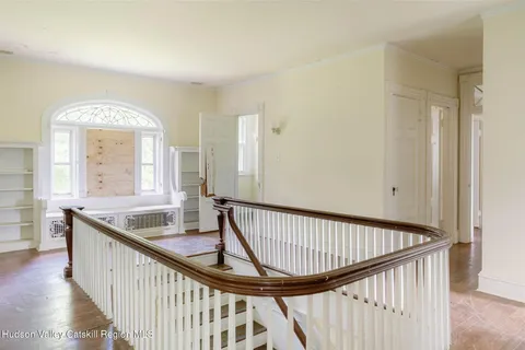 a view of staircase with railing and a window