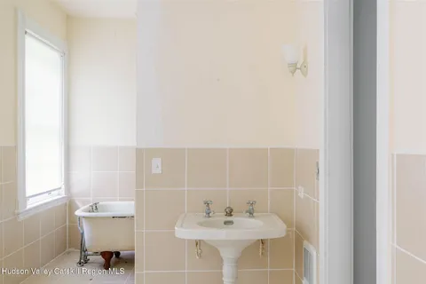 a view of a hallway view with wooden floor and a bathroom