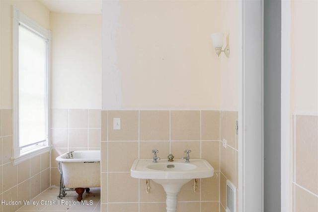 a view of a hallway view with wooden floor and a bathroom