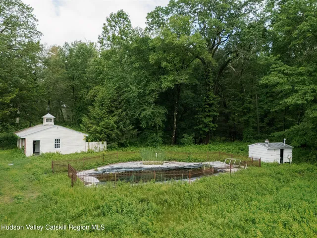 a view of a white house with a yard and potted plants