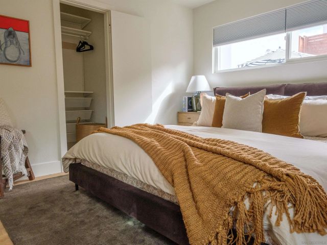 a bed sitting in a bedroom next to a window