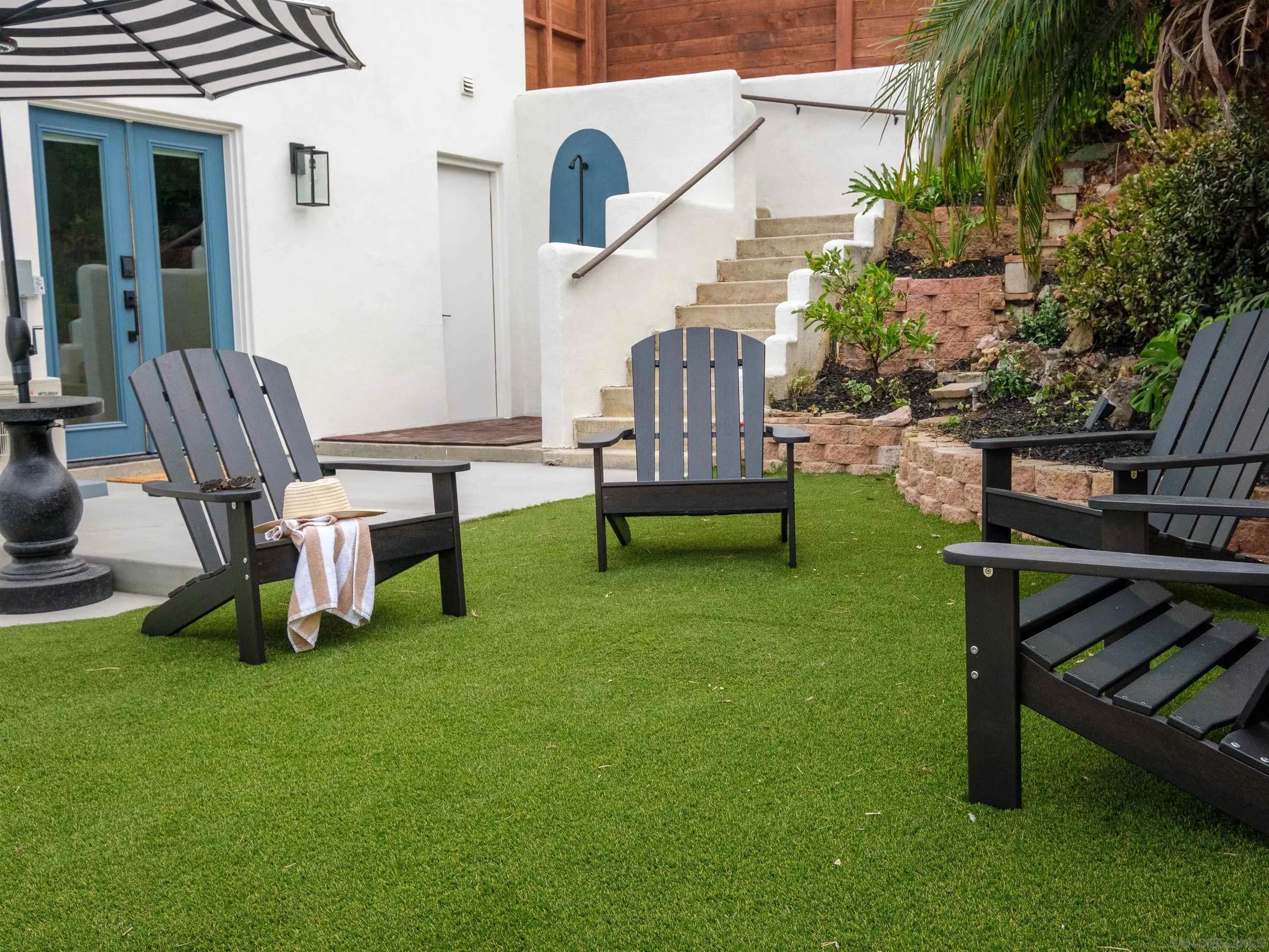 1915 Montgomery Avenue Cardiff-by-the-Sea, CA 92007 - Photo 24 of 32 a view of a backyard with chairs potted plants and wooden fence